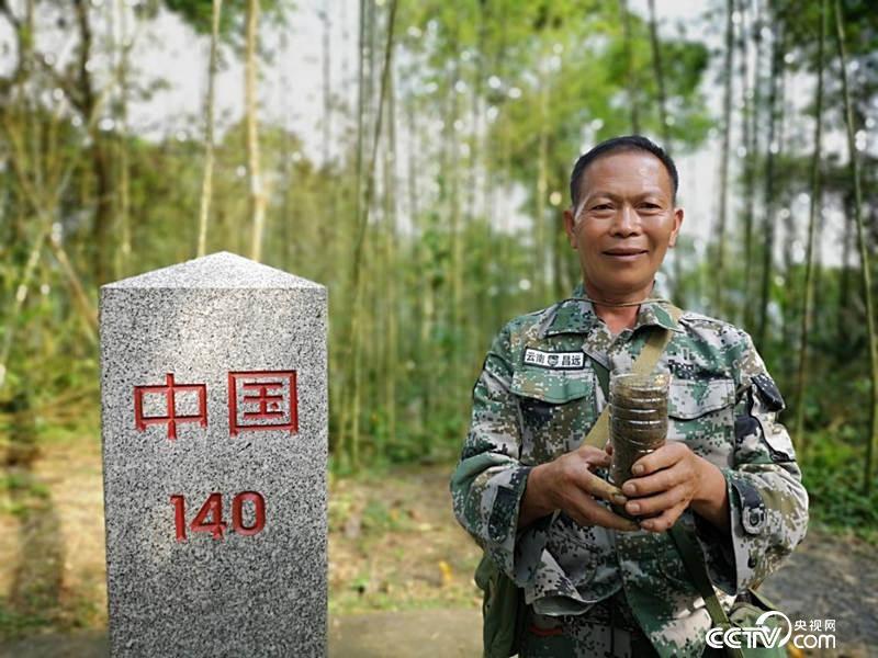 杨天才在界碑前取了一捧土，给记者带去北京。(何川 摄)